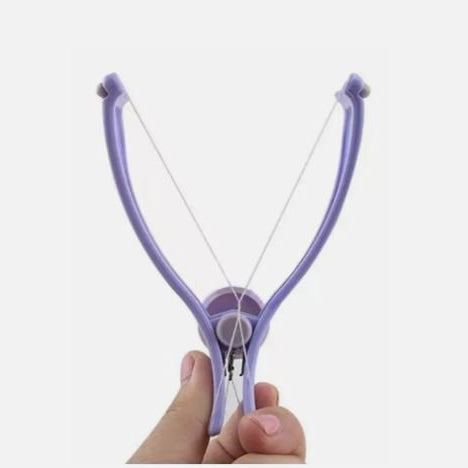 Purple slingshot held in a hand against a white background